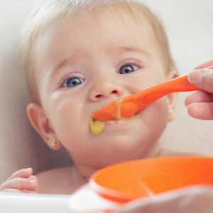 toddler eating food with thicker textures, spoon fed