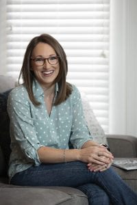 Allison Jandu is pictured sitting on a couch