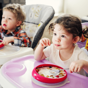 toddler eating with tv on