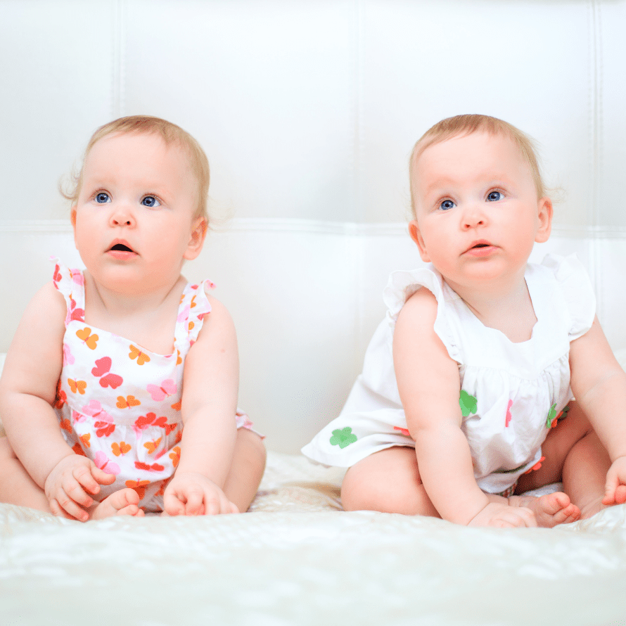 Episode art for episode: "#53: Starting Solids with Twins or Multiples". Pictured are twins sitting on a couch.