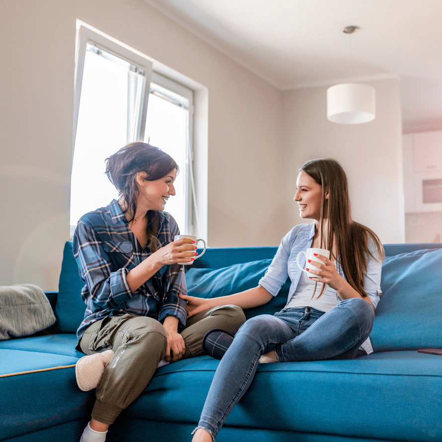 Featured image for the article: "Top tips from a friendship coach on making and maintaining friendships as a mom." Pictured is two friends chatting while having coffee.