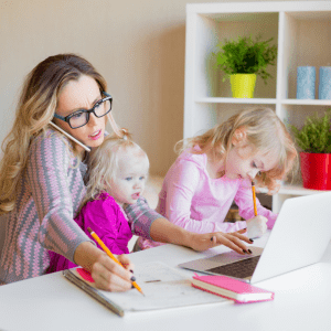 Featured image for article: "Feeding babies and toddlers: A military wife’s perspective". Pictured is a mom who is multi-tasking with a baby in her lap and toddler beside her.