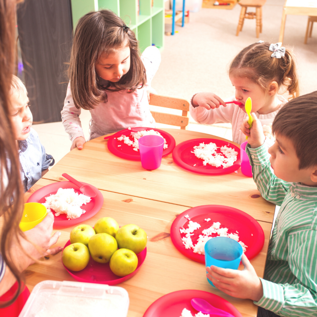 Toddlers eating together at the table during daycare