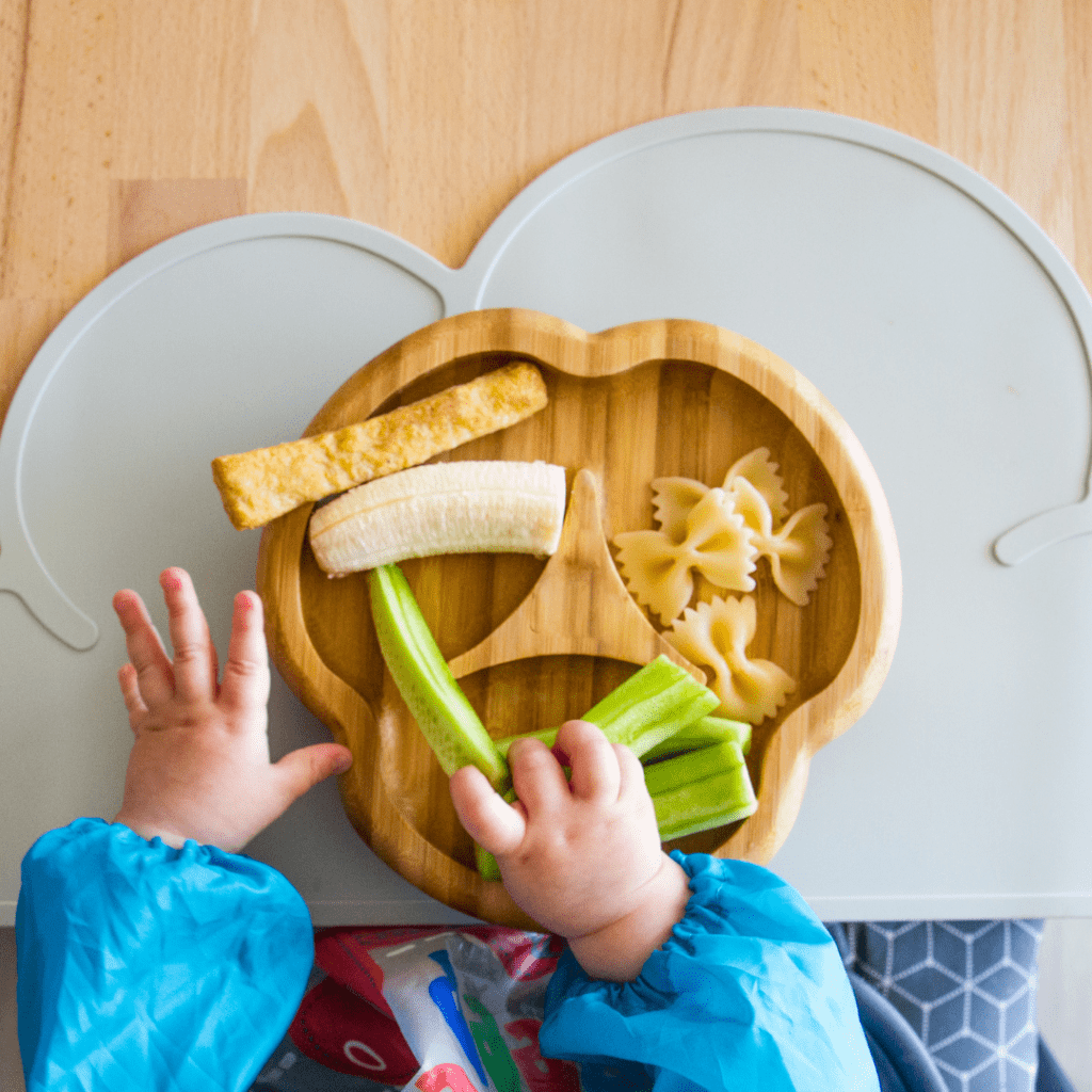 Baby uses palmar grasp to pick up finger foods for baby led weaning.